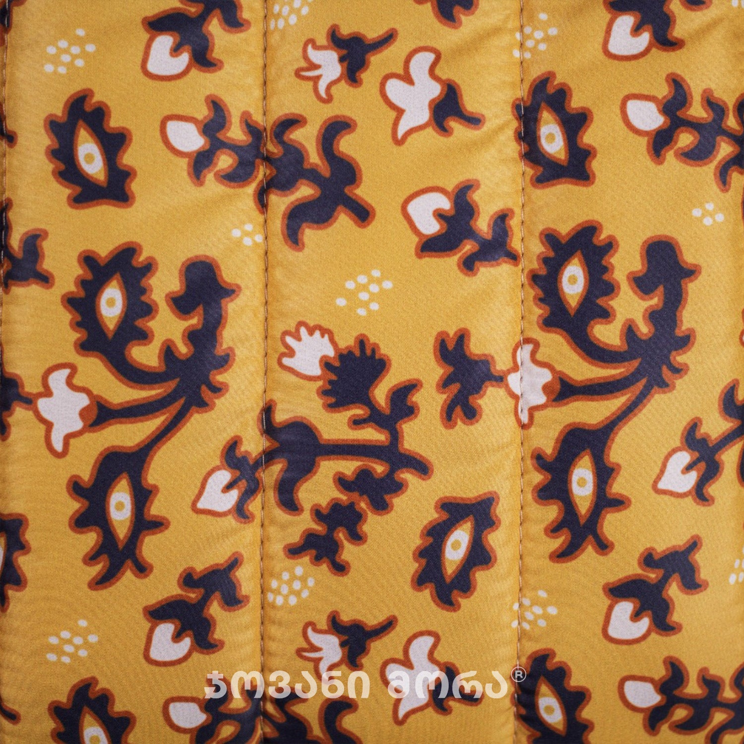 Close-up of Tholige Georgian ornament print on yellow padded laptop sleeve